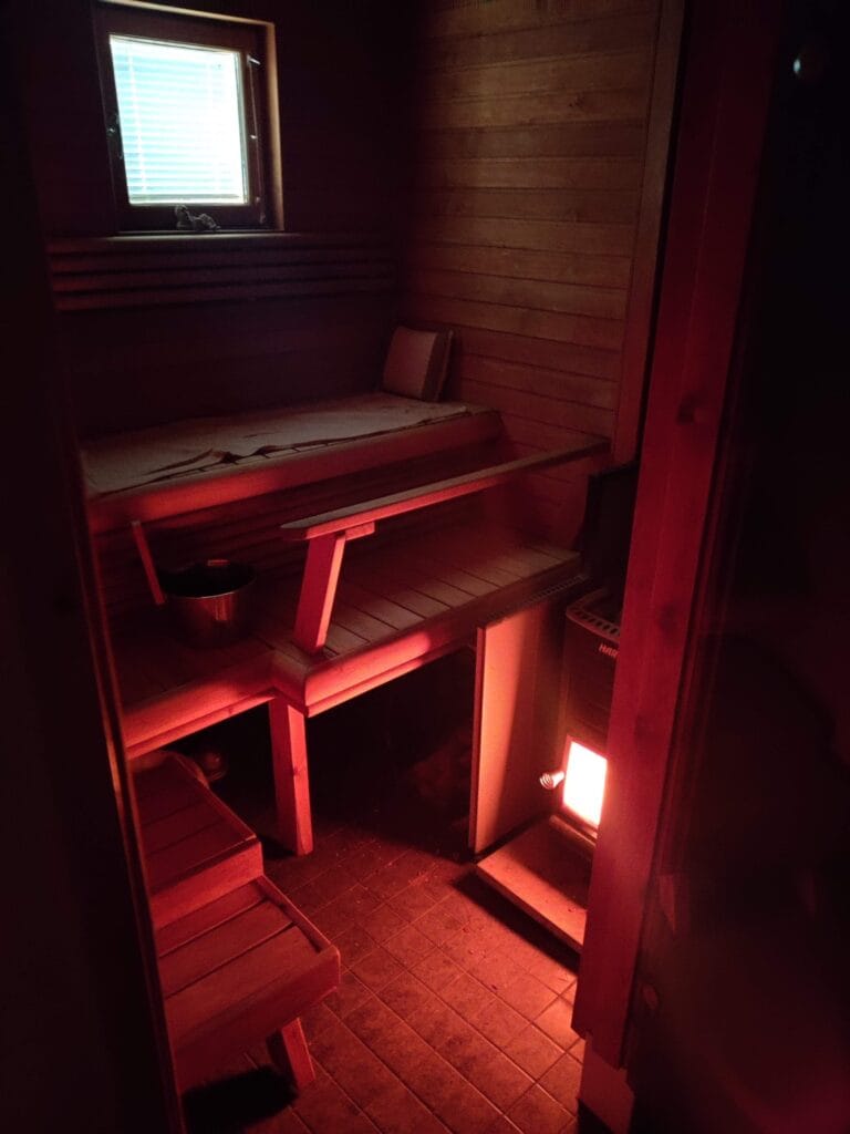 Traditional Finnish wood-fired sauna in Rovaniemi, featuring a cozy interior with wooden benches and a glowing stove.